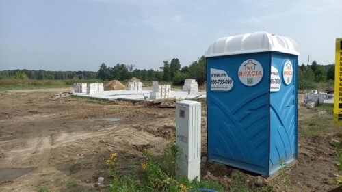 toaleta mobilna przy drodze dojazdowej do placu budowy
